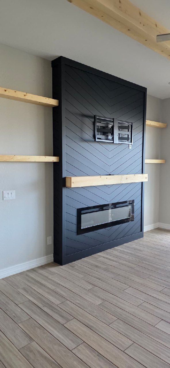 Black chevron TV wall under construction with exposed wooden ceiling beams Arizona