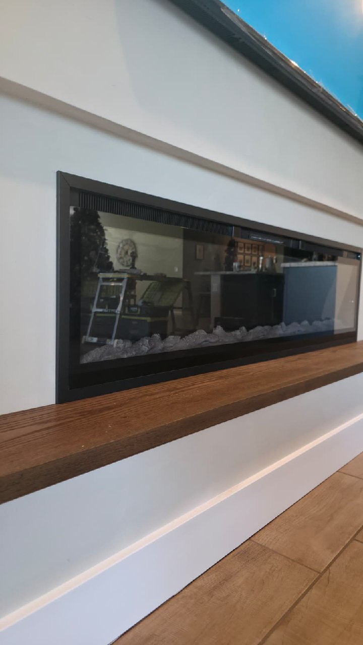 Close-up of linear electric fireplace with custom wood mantle Arizona