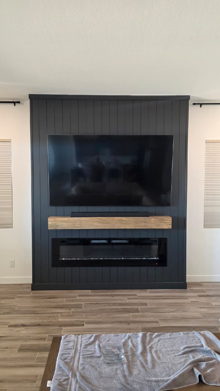 Natural stone ledger tile TV wall with blue LED fireplace and wooden ceiling beams Arizona