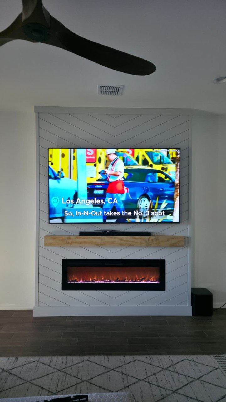 White chevron shiplap TV wall with orange flame fireplace and dark wood floor Arizona